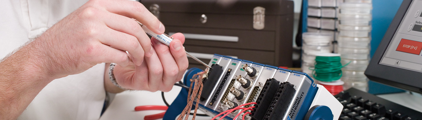 Researcher adjusting National Instruments equipment with screwdriver