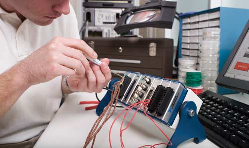 Researcher adjusting National Instruments equipment with screwdriver